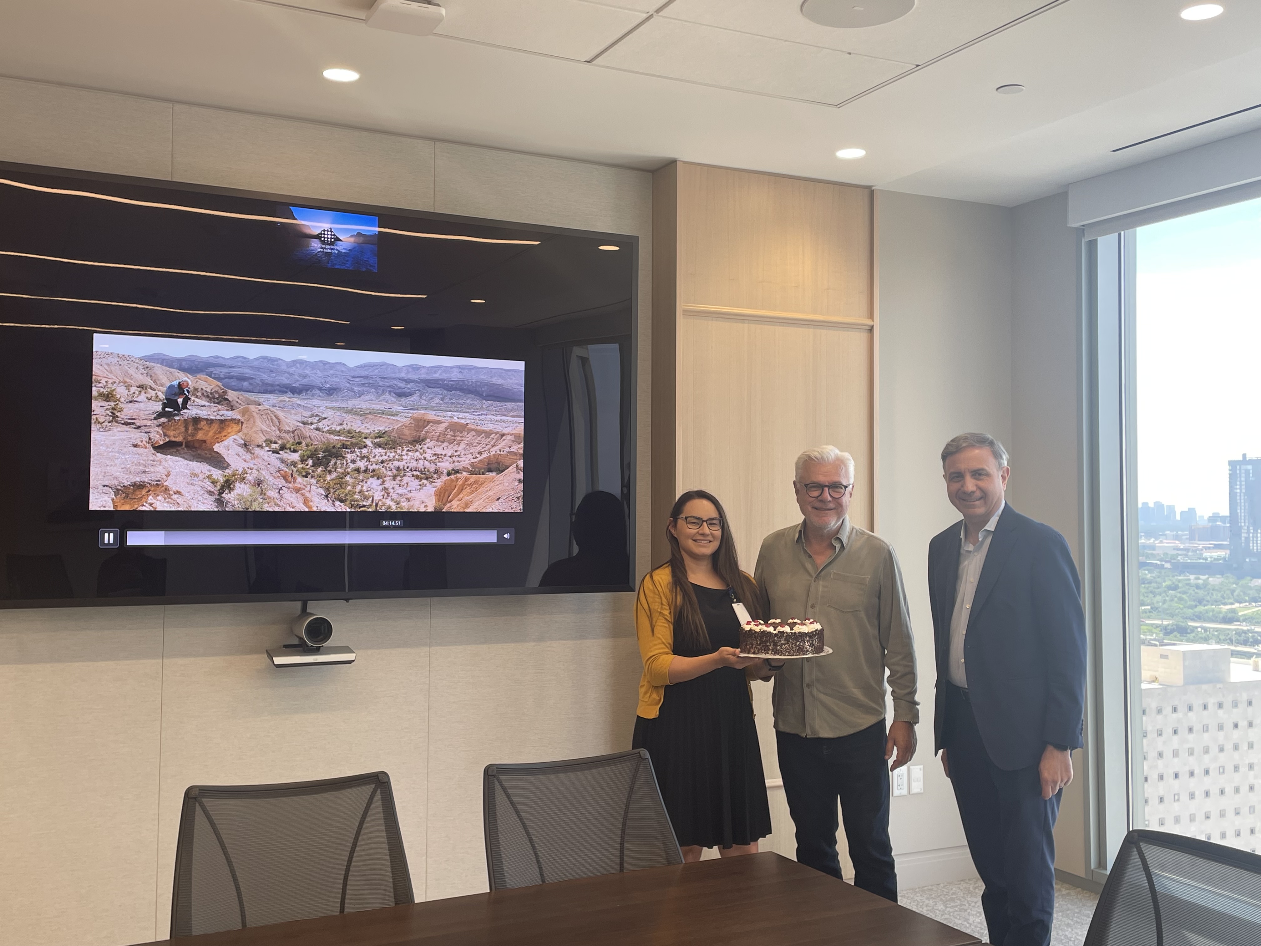 John Bernard and José Luis Vittor stand beside an image from John's presentation.