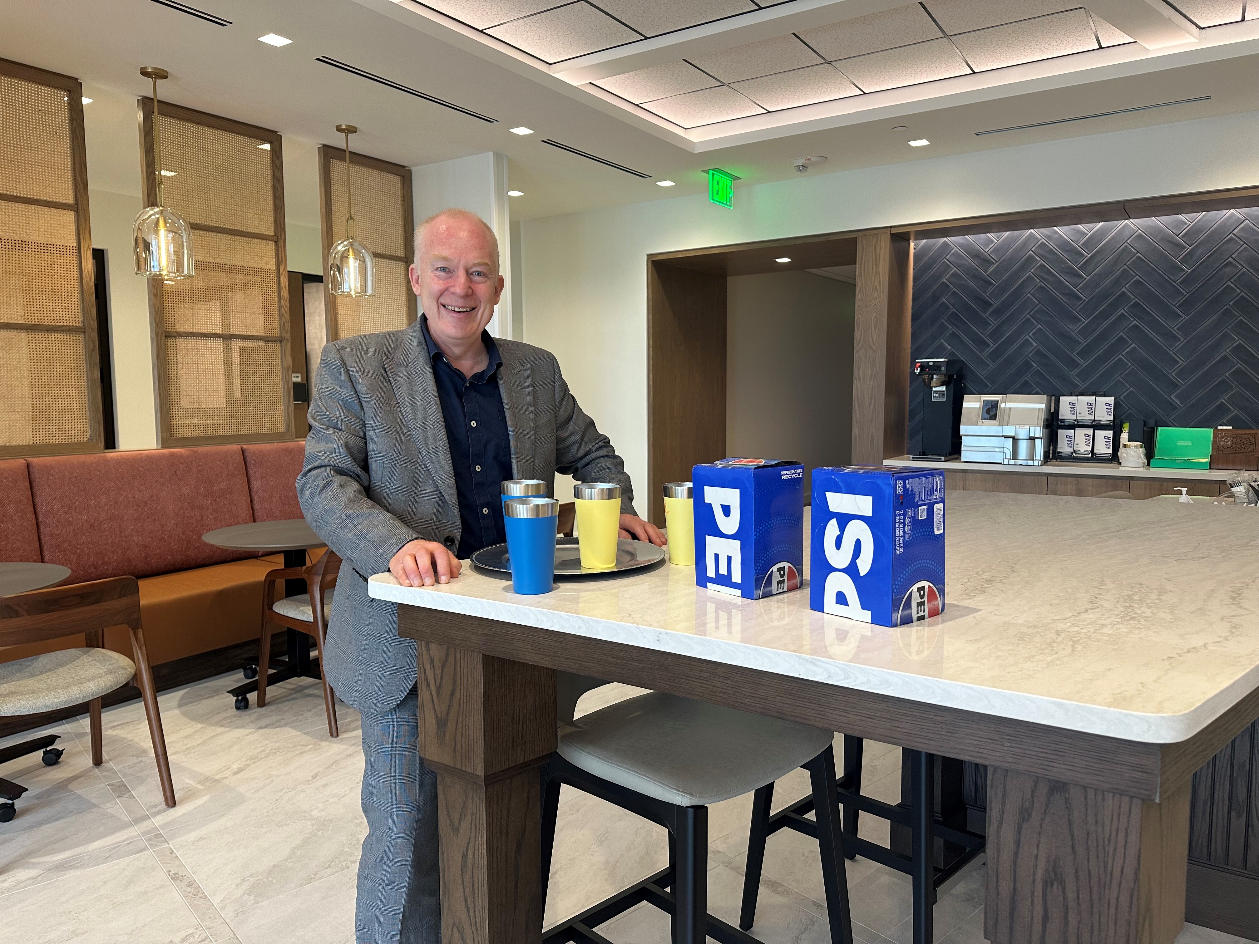 Attorney James Love stands beside a table.