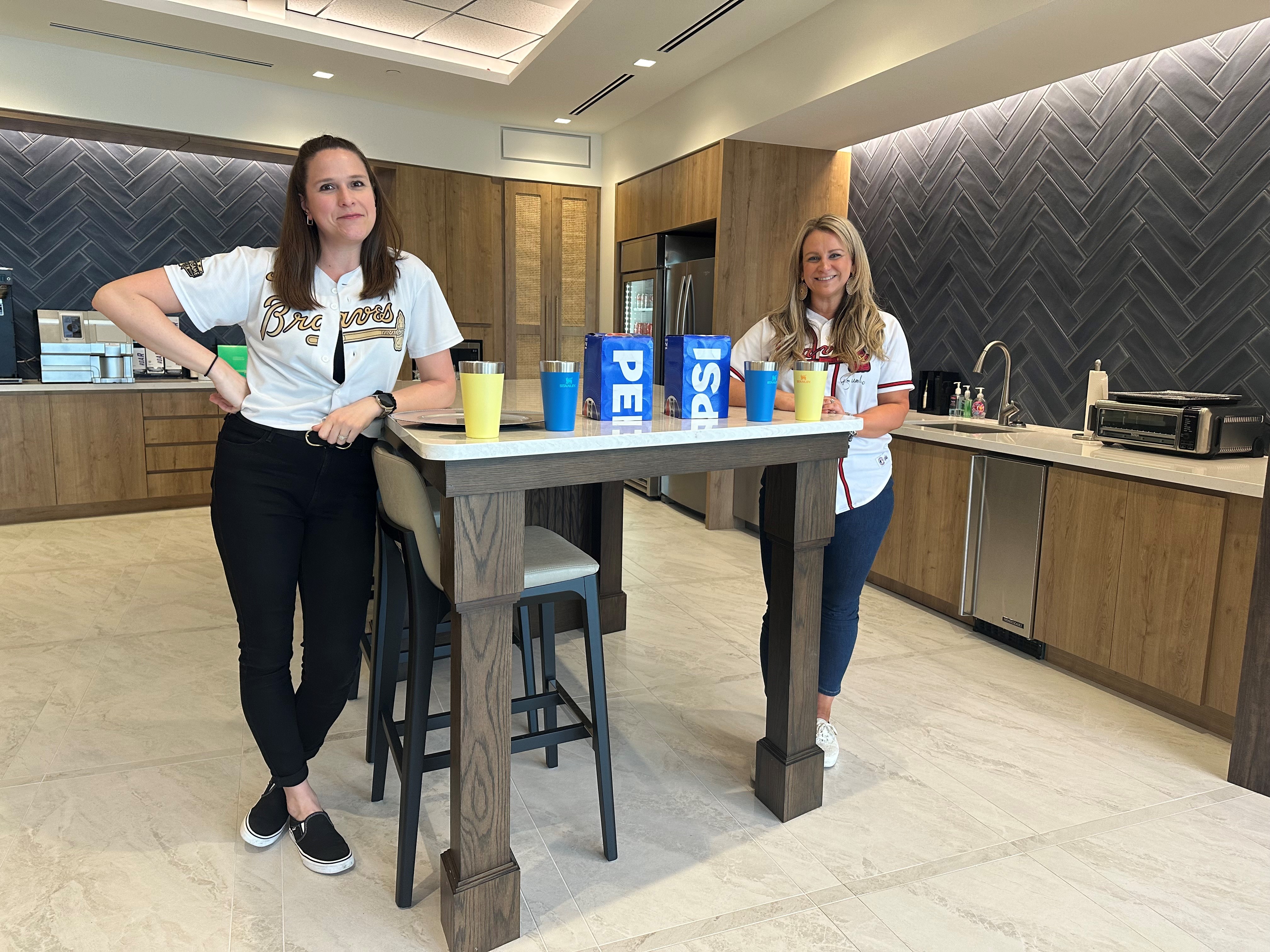 Events Manager Abbie Roberson and Business Development Strategist Kristen Vetula in Braves attire.