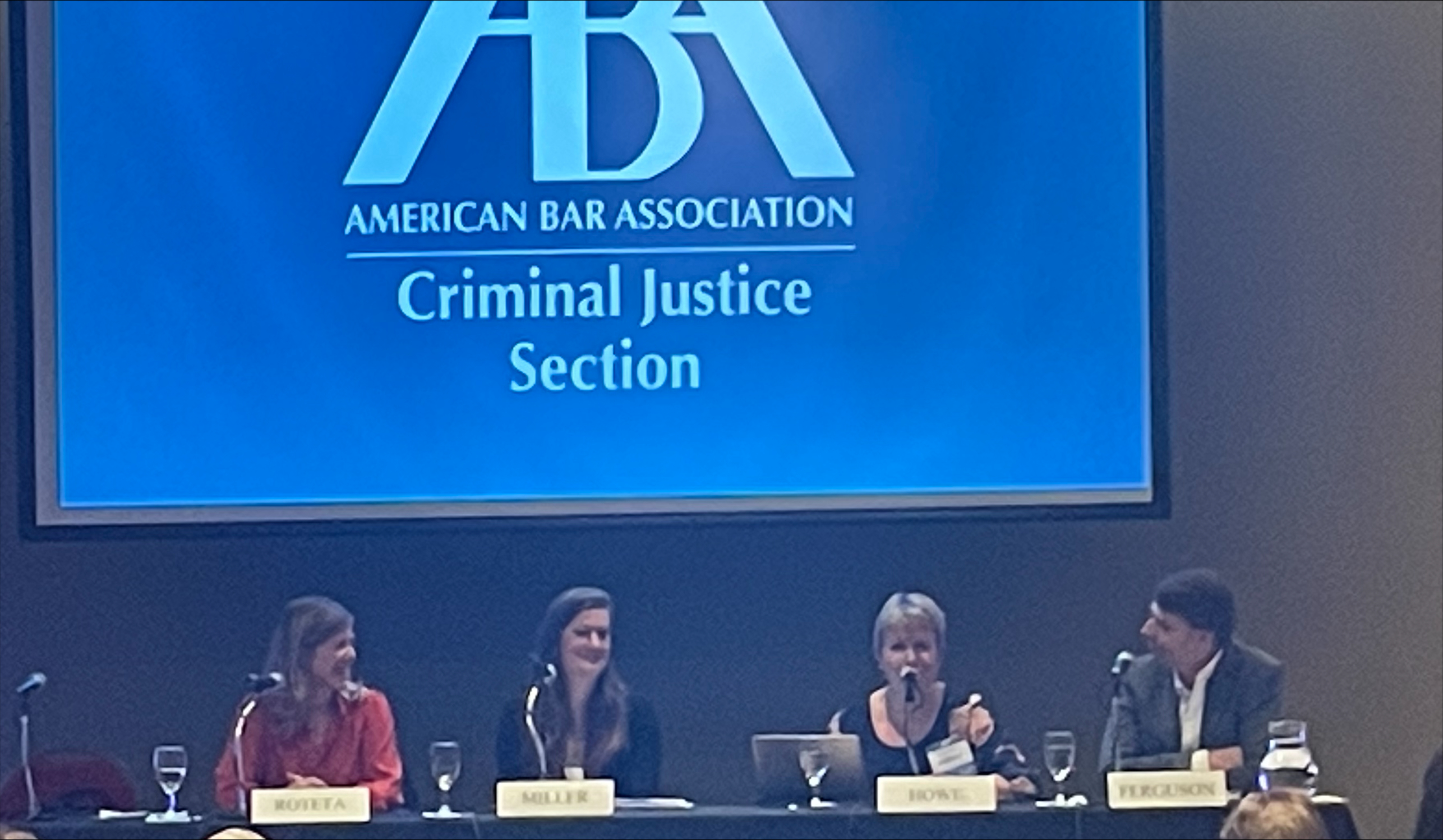 Laura Roteta, Lisa Miller and Russ Ferguson listen as Elizabeth Howe speaks during a panel discussion on enforcement trends and priorities.