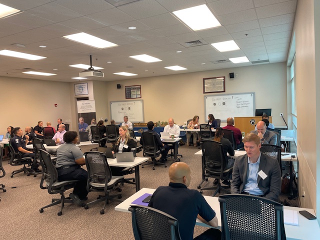First responders and attorneys sit in a large room at the Charlotte Police & Fire Training Academy.