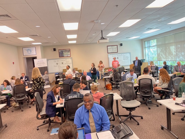 Groups of first responders and attorneys sitting at tables at the Charlotte Police & Fire Training Academy.