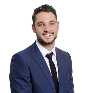 Professional young businessman smiling in a blue suit with a white shirt and black tie on a white background