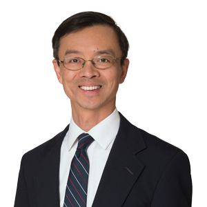 Professional man in business suit with tie posing for corporate headshot against white background