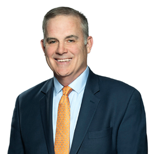 Professional middle-aged man with grey hair wearing a blue suit and orange tie, showcasing corporate leadership and experienced business expertise.