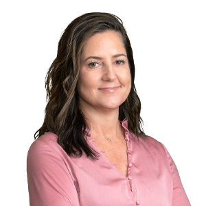 Professional woman with shoulder-length hair smiling in a pink blouse against a white background.