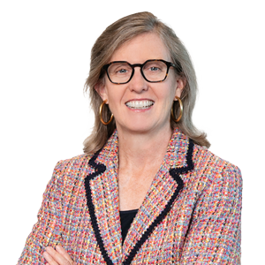 Professional woman in business attire with spectacles, smiling confidently against a clear background.