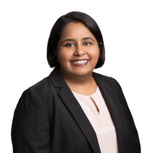 Professional woman in business attire smiling against a white background.