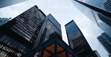 cLow-angle view of modern skyscrapers against a twilight sky, showcasing contemporary urban architecture in a bustling city centre.