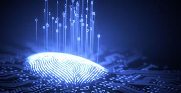 A thumbprint lights up on top of a print-reading surface, as data is gathered and symbolized by ones and zeros lifting up from the thumbprint.