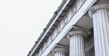 Classic Greco-Roman architecture with Corinthian columns in overcast British weather.
