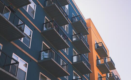 Modern urban apartment buildings with balconies against a clear sky, showcasing contemporary architecture in a city housing development.