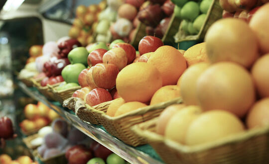 Baskets of apples and oranges in a supermarket