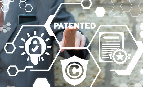 A businessman points at the word "PATENTED" surrounded by hexagons with a lock symbol, copyright symbol, and a piece of paper with a certification symbol.