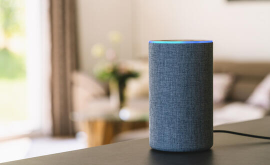 An Amazon Echo sits on a living room table.