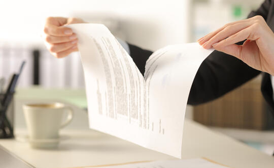 Businesswoman tearing document in half - Shutterstock 1703520760