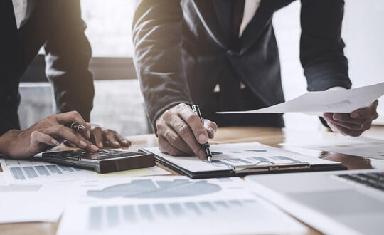 Business professionals in suits working on figures 