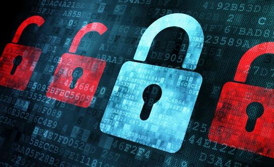 A row of locks lined up against a dark background with computer coding. Three of the locks are red and locked, and one is blue and unlocked.