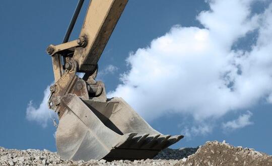 A crane lifting piles of dirt