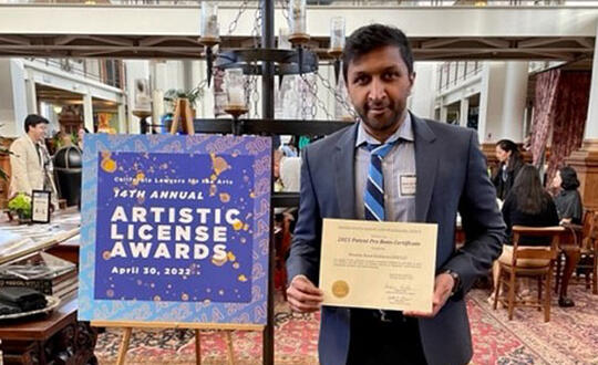 Attorney Jay Adisesh accepts an award for Womble Bond Dickinson from California Lawyers for the Arts.