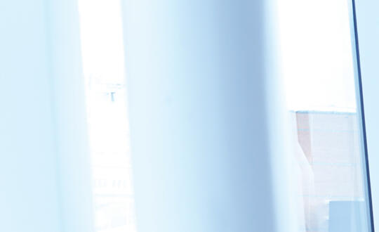 Photo depicts a young women attorney talking on her mobile in a spacious conference room.