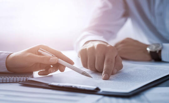 Two colleagues review a document - Shutterstock 763046476