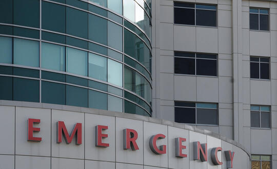 "EMERGENCY" is spelled out in large, red letters on a hospital.