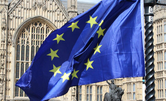 A European Union flag flies in front of a building.