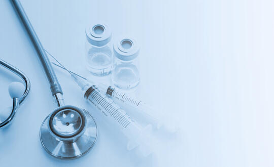 A stethoscope, two needs and two vials