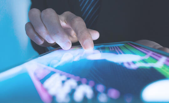 Fintech professional looking at a tablet screen