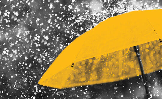 Yellow umbrella in rain