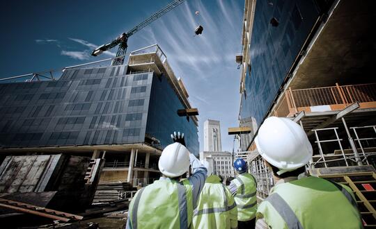 Construction workers looking at building