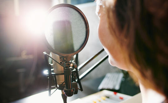 Woman speaking into podcast microphone