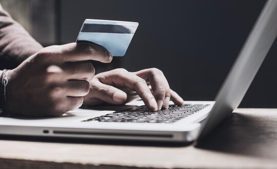 Person making bank transfer with card online laptop