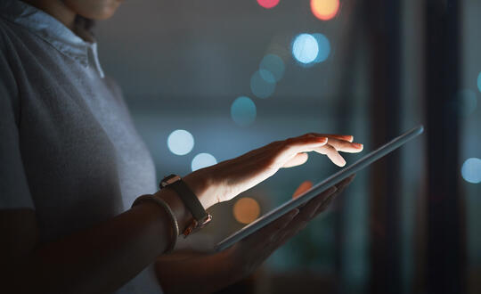 Person using tablet in dark office