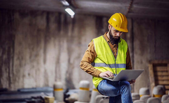 Construction worker using laptop onsite
