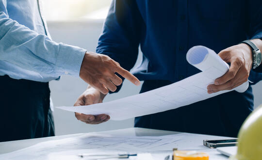 Two men reviewing property plans
