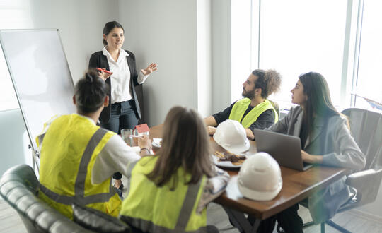 Construction workers sat in a meeting room