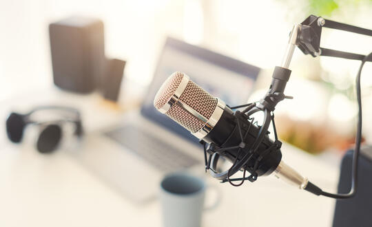 Podcast mic with laptop in the background