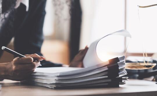 Man filling in paperwork at legal desk