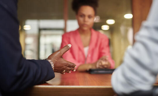 Woman sat next to a table facing two people