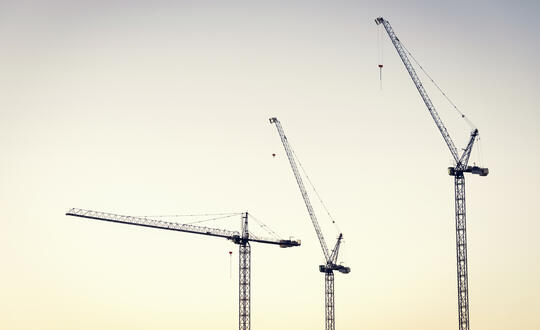 Construction cranes on horizon