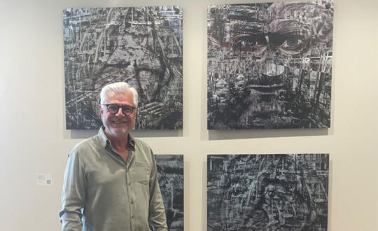 Artist John Bernard in front of his art titled Displaced.
