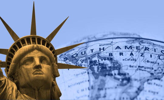 The Statue of Liberty stands beside a close-up of a map of Latin America.