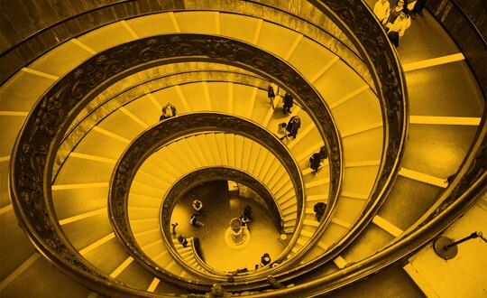 Bird's eye view of people walking down spiral staircase