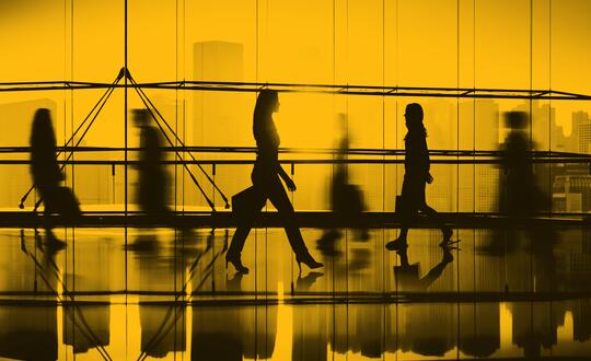 Picture of people walking with pace, blurred motion. Image edited with yellow wash.
