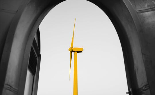 Wind turbine looking through an archway. Wind turbine is edited with a yellow wash.