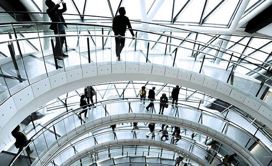 People walking round corporate building staircase