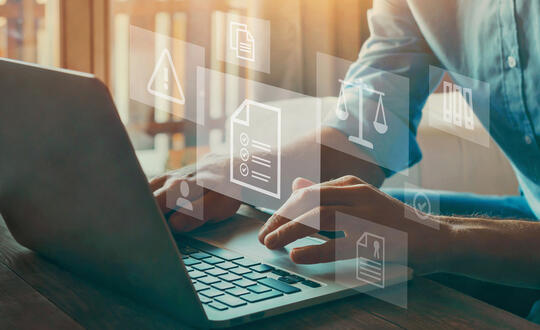 A person sits at a computer as messages pop up symbolizing documents and the legal field.